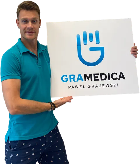 Paweł Grajewski trzymający tabliczkę gabinetu GraMedica
